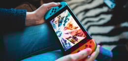 person playing nintendo switch sitting on couch